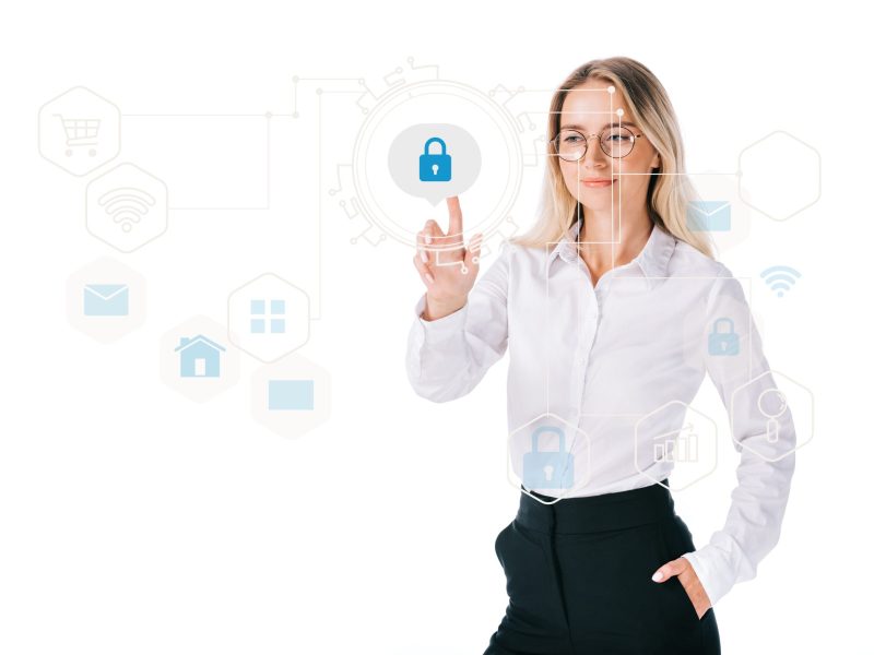 portrait of smiling businesswoman in formal wear pointing at cyber security sign isolated on white